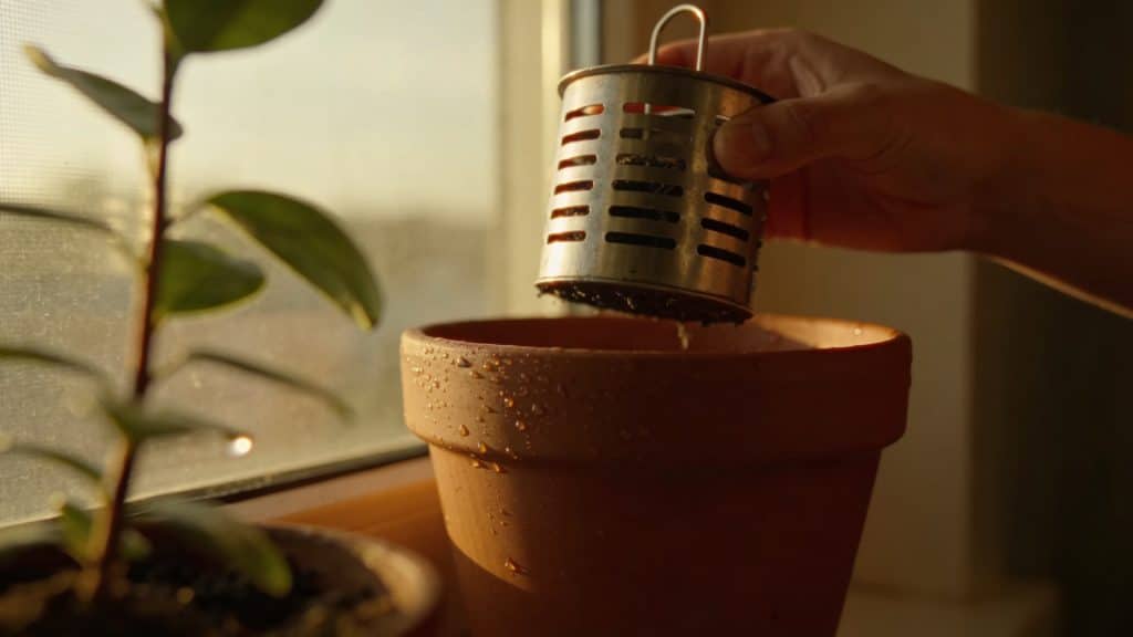 mains tenant un aérateur de compost maison en metal