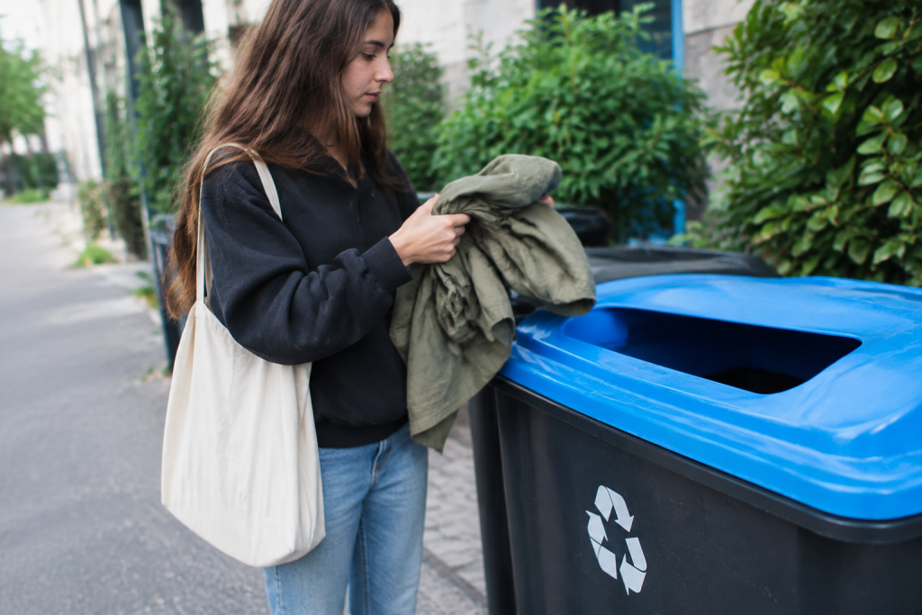 Vetements plies pres d'une poubelle de recyclage